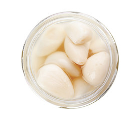 Glass jar with preserved garlic on white background, top view