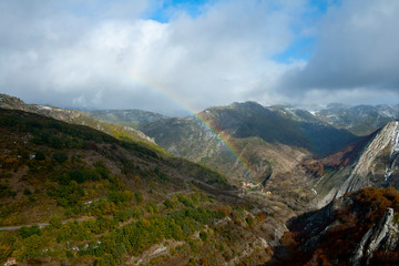 Rainbow in a mountainous landscape with beech forests.