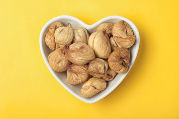 Bowl with dried figs on color background, top view. Healthy fruit