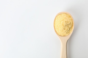 Spoon of corn flour isolated on white, top view with space for text