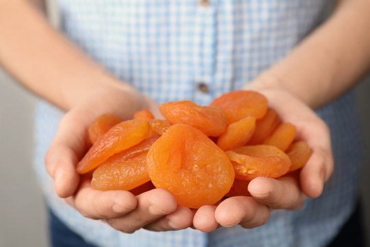 Woman Holding Handful Of Dried Apricots, Closeup. Healthy Fruit