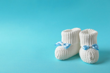 Handmade baby booties on color background. Space for text