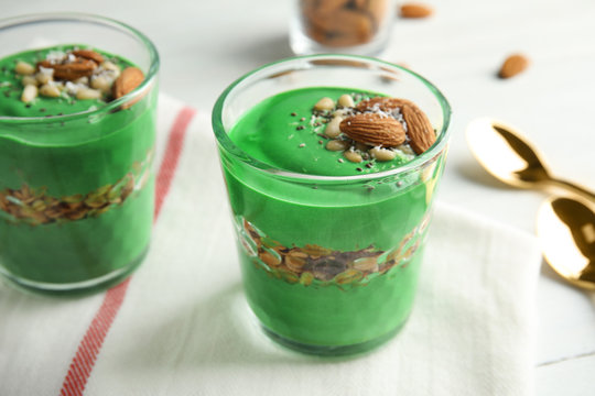 Glass cups of spirulina smoothie on table