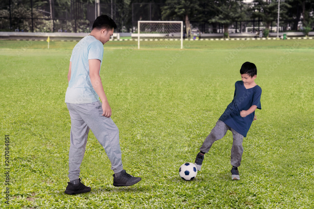 Sticker Child and father passing a ball during play football