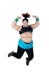 Happy overweight woman jumps on studio