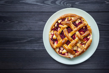 fruit cake in a plate on a dark wooden background.