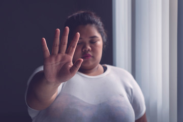 Obese woman showing hand gesture to stop