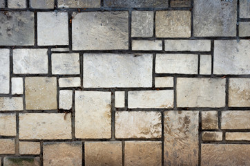 Full frame shot of  old stone wall with square and rectangle  stones with grey cement   between