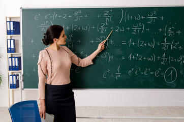 Female teacher standing in front of chalkboard   