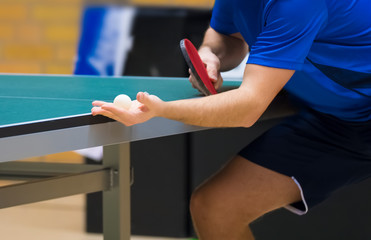 Table tennis player serving, close-up