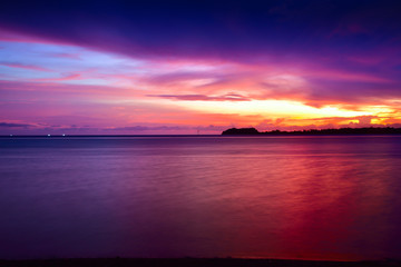 Obraz premium Sunset at a pacific tropical beach with calm peaceful ocean wave with sandy beach in the family couple resort