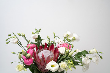 White lisianthus flowers with king protea on white background