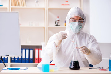 Young handsome chemist working in the lab 