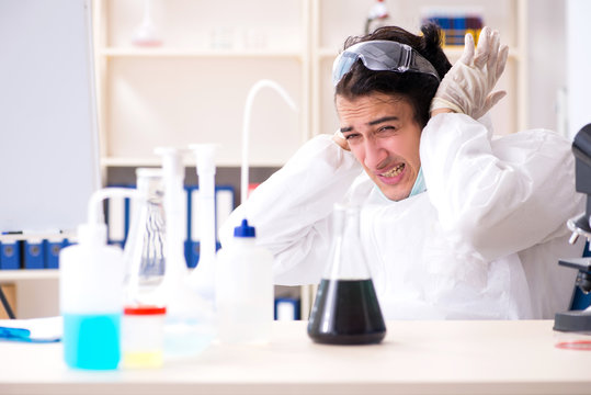 Young handsome chemist working in the lab 