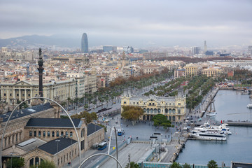 Aerial view over historical city center of Barcelona Spain with La Rambla main street, square Portal de la pau, Port Vell marina and Columbus Monument after sunset.