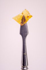 Detail of dab tool with cannabis concentrate aka shatter isolated