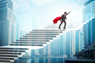 Superhero businessman climbing career ladder