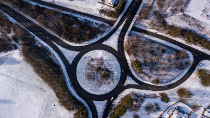 Aerial drone view of a traffic roundabout surrounded by fresh snowfall (Ebbw Vale, Wales, UK)