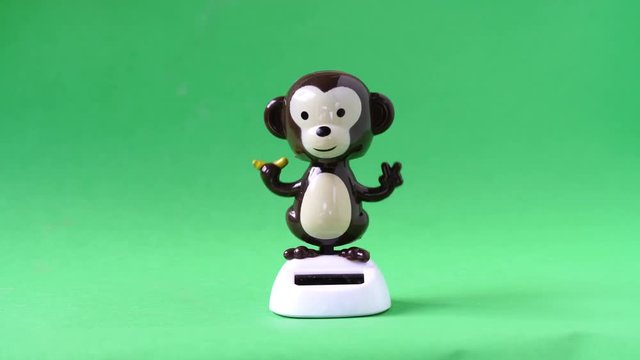 Monkey doll dancing on green screen background.