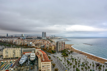 Fototapeta premium Aerial view over historical city center of Barcelona Spain with La Rambla main street, square Portal de la pau, Port Vell marina and Columbus Monument after sunset.