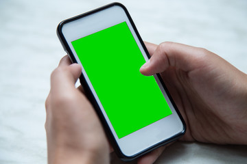 Person hand using mobile smartphone with green screen