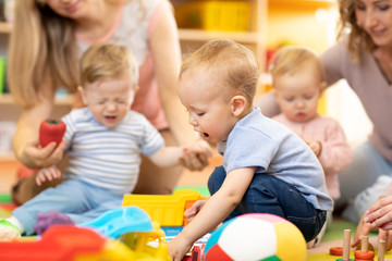 babies with moms playing in day care centre