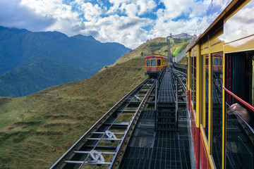 Fototapeta na wymiar Tourist mountain tram, the transporation to Fansipan cable car station in Sapa town, Vietnam, with mountain landscape scene