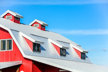 Top roof of new red barn on blue sky background © Imagenet