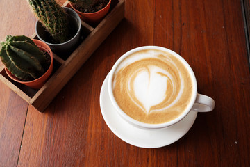 Hot coffee latte on a wooden table.