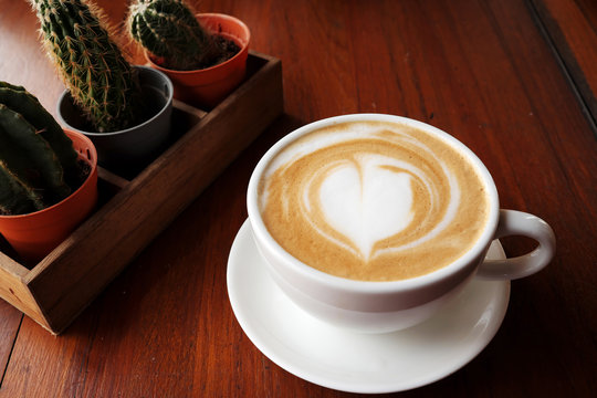 Hot coffee latte on a wooden table.