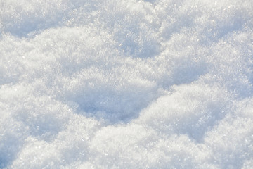 White crystals of snow on flat surface. Texture background