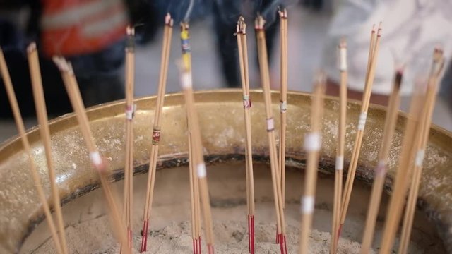 Incense sticks burn in Buddhist temple - close up view.