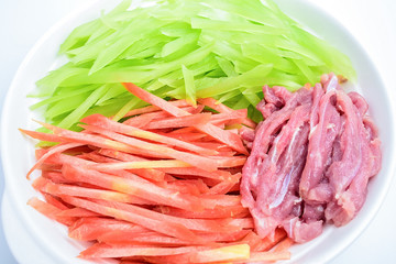 Chopped lettuce, carrot, pork, and ingredients for cooking