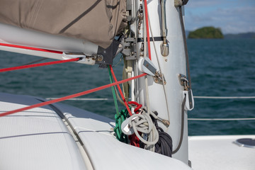 View of the blue sea water from the side of a sailboat with rigging and sails. Tackle barge, sail, masts, yards, deck, ropes, cables
