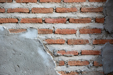 Damaged wall of an old barely standing building. Old wall surface is ruptured by time