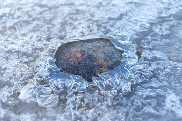 stone on ice in a frozen lake