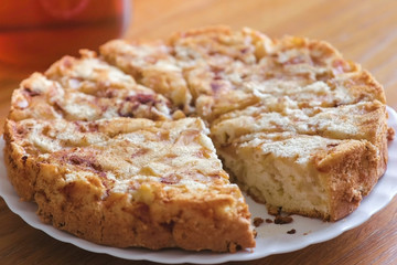 Homemade apple pie on the plate on wooden table.