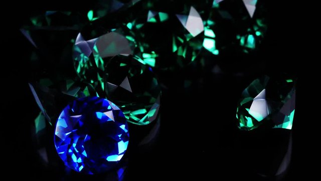Gemstones rotate on a stand on a black background. Close up.