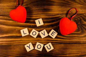 Two red hearts on a wooden table. 
