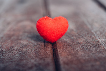 Red heart stand on wooden background,