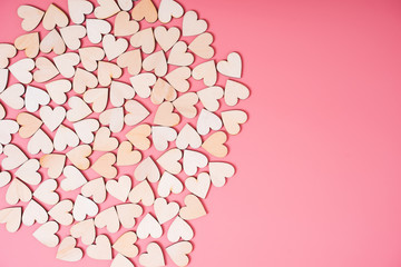 Wood hearts on pink background with copy space,