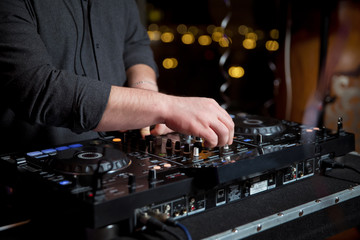 Hand mixing music on dj controller with social media concept icons .Dj playing disco house progressive electro music at the concert. DJ hands on equipment