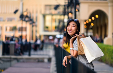 Girl with shopping bags in front of a mall