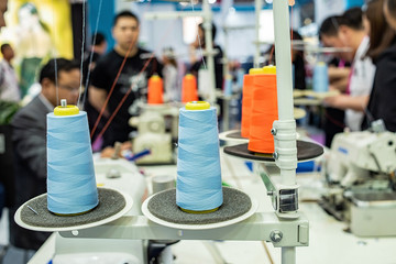 Sewing thread on sewing machine in garment factory workshop