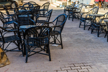 Fototapeta na wymiar Empty tables and chairs in a street cafe