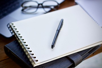 notebook and pen on wooden table
