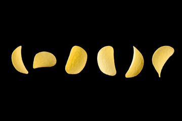 Falling potato chips isolated on black background. Levitating crispy snacks