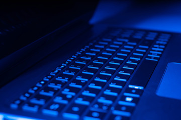 Ge&ouml;ffneter Laptop in blauem Licht