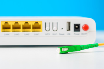 Fiber optical cable and internet wireless router on a blue background