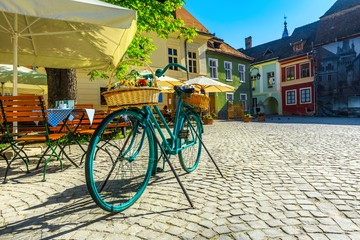 Gorgeous medieval street cafe bar and paved street, Sighisoara, Romania